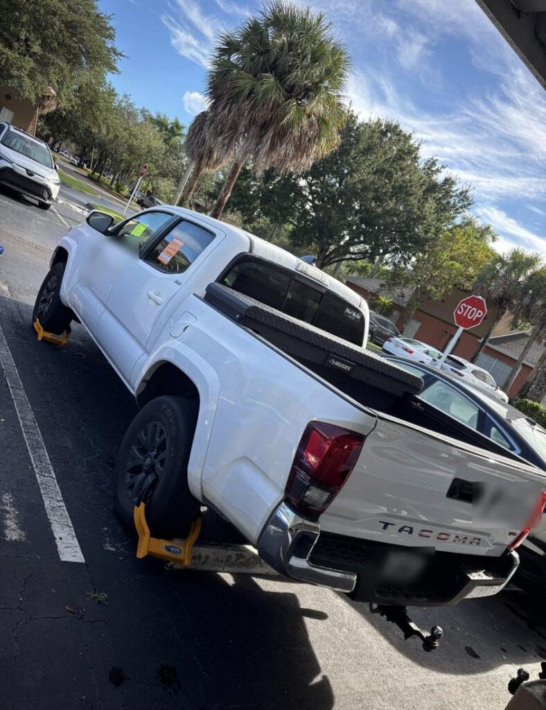 Booted pickup truck in a community lot